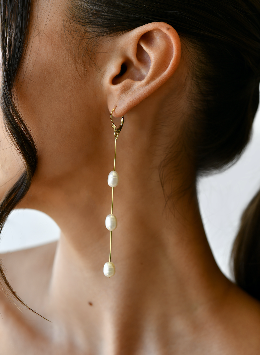 14K Yellow Gold Fresh Water Pearl Dangling Earrings with model's ear