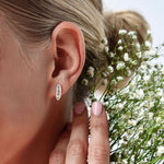 18K White Gold Baguette and Round Diamond Huggie Hoop Earrings with model's ear